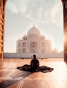 hombre sentado de espalda meditando con el taj Mahal en frente